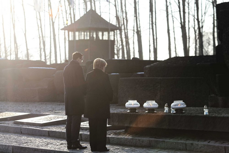 Kanclerz Niemiec Angela Merkel (P) i premier Mateusz Morawiecki (L) zapalają znicze przy Międzynarodowym Pomniku Ofiar Obozu na terenie byłego niemieckiego nazistowskiego obozu zagłady Auschwitz II-Birkenau. Fot. PAP/A. Grygiel