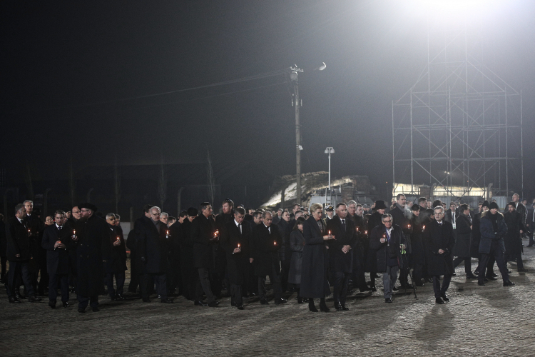 rezydent RP Andrzej Duda (C) z małżonką Agatą Kornhauser-Dudą (C-L) oraz były więzień Marian Turski (P) podczas uroczystości zapalenia zniczy przed Międzynarodowym Pomnikiem Ofiar Obozu na terenie byłego obozu w Oświęcimiu. Fot. PAP/Ł. Gągulski