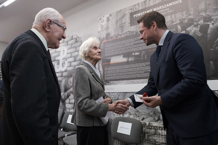 Prezydent Warszawy Rafał Trzaskowski (P), wiceprezes Środowiska Żołnierzy Pułku Armii Krajowej Baszta i innych mokotowskich Oddziałów Powstańczych Tadeusz Kostarski (L) oraz sanitariuszka w pułku „Baszta” Lucyna Nahorska (C) podczas uroczystości wręczenia prezydentowi odznaki honorowej pułku AK Baszta „Amicitiae Fidelium”. Fot. PAP/M. Marek