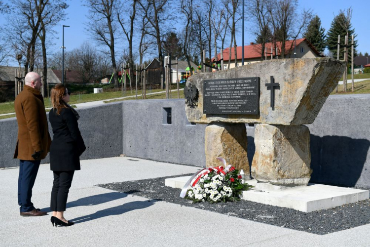 Markowa, 24.03.2020. Wójt gminy Markowa Mirosław Mac (L) i dyrektor Muzeum Polaków Ratujących Żydów podczas II wojny światowej w Markowej Anna Stróż-Pawłowska (2L) podczas zapalenia znicza przed obeliskiem rodziny Ulmów w Sadzie Pamięci w Markowej, w Narodowym Dniu Pamięci Polaków ratujących Żydów pod okupacją niemiecką. Z powodu pandemii koronawirusa oficjalne uroczystości zostały odwołane. Fot. PAP/D. Delmanowicz