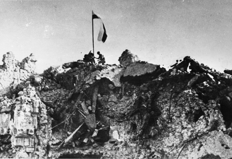 Po zwycięskiej walce patrol z 12. Pułku Ułanów Podolskich zatyka polską flagę nad rumowiskiem klasztoru Monte Cassino. 18.05.1944. Fot. PAP/CAF