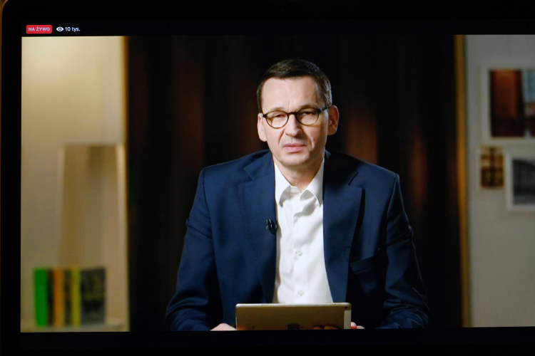 Warszawa, 21.04.2020. Koronawirus w Polsce. Premier Mateusz Morawiecki (na ekranie) podczas sesji pytań i odpowiedzi - Q&A z internautami, zorganizowanej na profilu szefa rządu na Facebooku. Fot. PAP/M. Marek