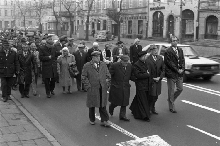 Warszawa 11.11.1989. II Kongres PSL tzw. wilanowskiego. Przemarsz ul. Krakowskie Przedmieście uczestników Kongresu na mszę św. do bazyliki archikatedralnej św. Jana Chrzciciela; w pierwszym rzędzie, m.in. prezes PSL-Wilanów Franciszek Kamiński (2L), ks. prałat Bogusław Bijak (3L), w drugim rzędzie, m.in. wiceprezesi PSL-Wilanów Franciszek Kieć (3L), Hanna Chorążyna (4L) i Stanisław Laskowski (5L). Fot. PAP/L. Wawrynkiewicz