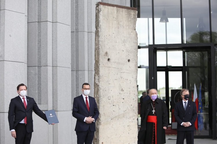 Warszawa 18.05.2020. Premier Mateusz Morawiecki, dyrektor muzeum Marcin Adamczewski, ambasador Republiki Federalnej Niemiec w Polsce Rolf Nikel oraz metropolita warszawski, kardynał Kazimierz Nycz podczas uroczystości przekazania fragmentu Muru Berlińskiego do Muzeum Jana Pawła II i Prymasa Wyszyńskiego w 100. rocznicę urodzin Jana Pawła II. PAP/L. Szymański