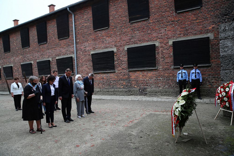 Europoseł PiS Beata Szydło (L), byłe więźniarki obozu Barbara Wojnarowska-Gautier (2L) i Lucyna Adamkiewicz (4P), wicepremier, minister kultury i dziedzictwa narodowego Piotr Gliński (3P), prezydent Andrzej Duda (5P) oraz marszałek Sejmu Elżbieta Witek (3L) składają wieńce pod Ścianą Straceń na dziedzińcu bloku 11 w byłym obozie Auschwitz I. 14.06.2020. PAP/Ł. Gągulski