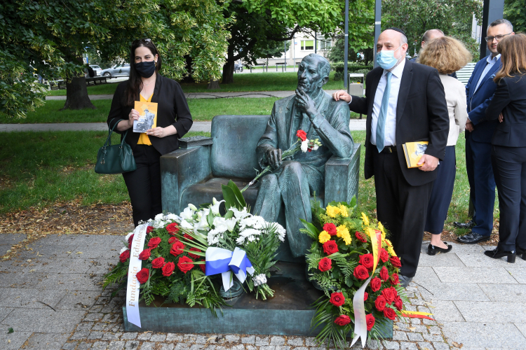 Warszawa, 12.07.2020. Wiceambasador Izraela Tal Ben-Ari Yaalon (L) i naczelny Rabin RP Michael Schudrich (2L) podczas złożenia kwiatów przy pomniku-ławeczce Jana Karskiego przy muzeum POLIN. Fot. PAP/R. Pietruszka