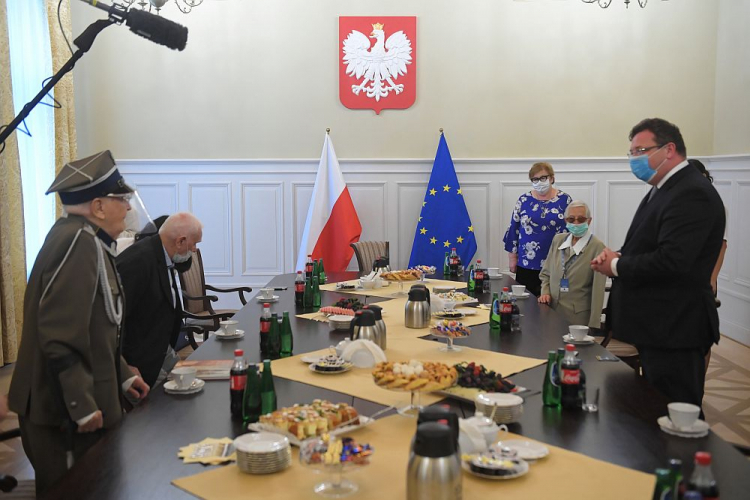 Wiceminister sprawiedliwości Michał Wójcik (P) i uczestnicy Powstania Warszawskiego Krystyna Marcinkiewicz (2P), Józef Polak (L) i Adam Racki (2L) podczas spotkania w siedzibie resortu sprawiedliwości. Warszawa, 31.07.2020. Fot. PAP/R. Pietruszka