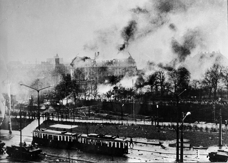 Grudzień ’70: płonący gmach Komitetu Wojewódzkiego Polskiej Zjednoczonej Partii Robotniczej przy Wałach Jagiellońskich w Gdańsku (C), z lewej kościół Świętej Elżbiety (wieża), widok od ul. 3 Maja. Fot. PAP/E. Pepliński