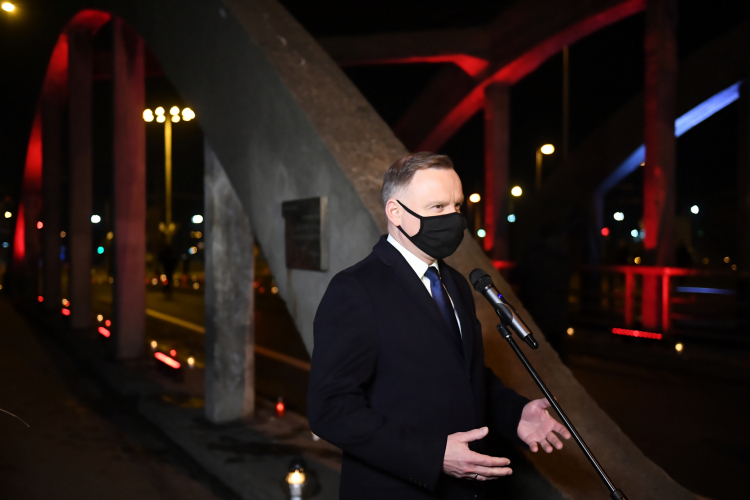 Prezydent RP Andrzej Duda podczas wystąpienia przed tablicą upamiętniającą wydarzenia z dnia 17.12.1970 r. na wiadukcie przy stacji SKM Gdynia Stocznia. Fot. PAP/A. Warżawa