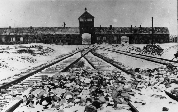 Tory kolejowe, wartownia i brama główna Auschwitz II (Birkenau), widok z rampy wewnątrz obozu, 1945 r. Źródło: Bundesarchiv