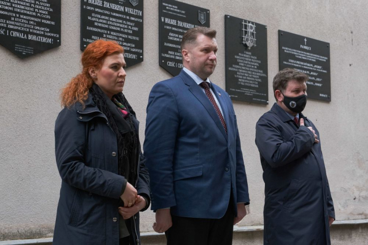 Warszawa, 25.05.2021. Obchody 73. rocznicy upamiętniania zamordowania rtm. Witolda Pileckiego - Międzynarodowy Dzień Bohaterów Walk z Totalitaryzmem. Minister edukacji i nauki Przemysław Czarnek (C), rzecznik MEiN Anna Ostrowska (L) i członek Grupy Historycznej Zgrupowanie „Radosław”, dziennikarz Jarosław Wróblewski (P) składają wieniec pod ścianą śmierci ku czci rtm. Witolda Pileckiego, na terenie byłego Aresztu Śledczego Warszawa-Mokotów. Fot. PAP/M. Marek