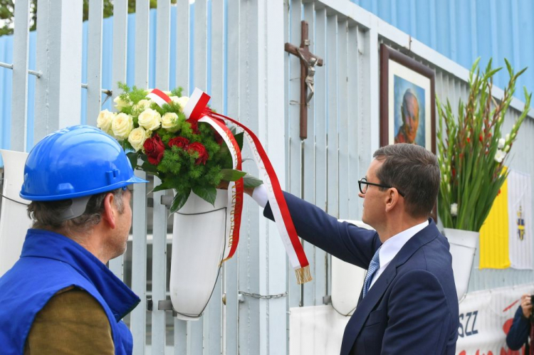 Gdańsk, 31.08.2021. Premier Mateusz Morawiecki (P) podczas uroczystości złożenia kwiatów przy historycznej Bramie nr 2 Stoczni Gdańskiej, 31 bm. Uroczystość poprzedziła przemarsz do Bazyliki św. Brygidy w Gdańsku. Trwają obchody 41. rocznicy podpisania Porozumień Sierpniowych. Fot. PAP/A. Warżawa 