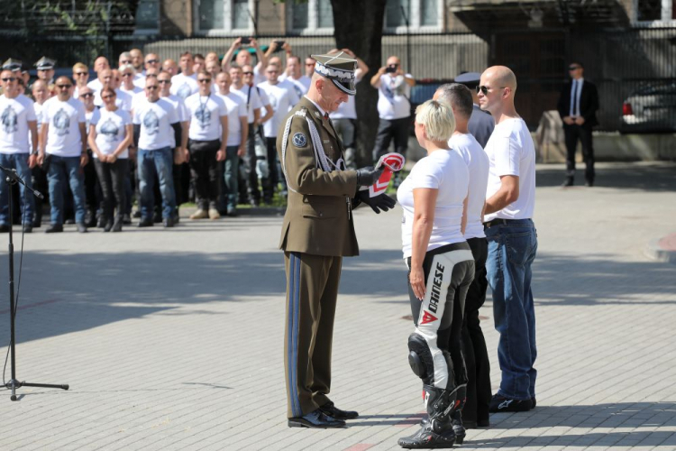 Szef SGWP generał Rajmund Andrzejczak (C) podczas przekazania flagi uczestnikom rajdu motocyklowego z okazji Święta Wojska Polskiego w Sztabie Generalnym WP w Warszawie. 13.08.2021. Fot. PAP/A. Zawada