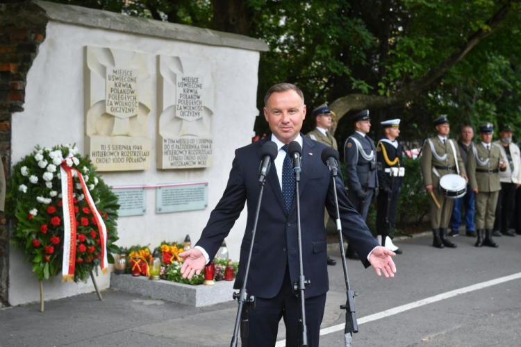 Prezydent RP Andrzej Duda (C) podczas uroczystości złożenia wieńca przed tablicami na fragmencie muru fabryki J. Franaszka. Fot. PAP/R. Pietruszka