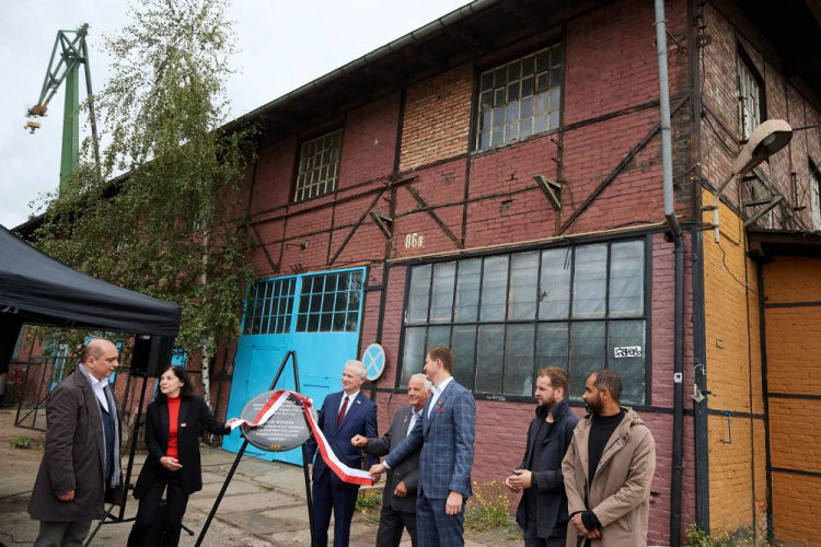 Dyrektor Europejskiego Centrum Solidarności w Gdańsku Basil Kerski (L), działaczka antykomunistyczna Bożena Grzywaczewska (2L), senator KO Sławomir Rybicki (3L), działacz związkowy i opozycjonista w okresie PRL Jan Rulewski (4L) i zastępca prezydenta Gdańska Piotr Grzelak (5L) podczas odsłonięcia tablicy pamiątkowej przed warsztatem, w którym pracował Lech Wałęsa. Fot. PAP/A. Warżawa