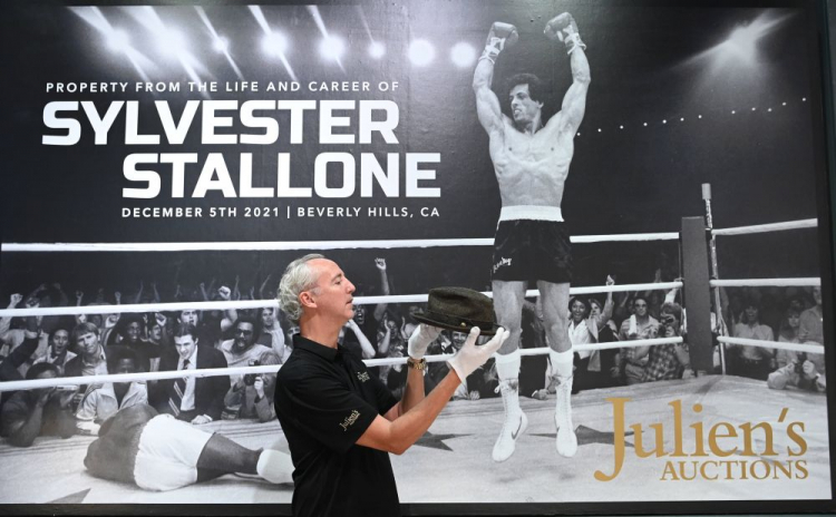 Prezentacja pamiątek Sylvestra Stallone'a wystawionych na aukcję, w tle fotografia aktora jako Rocky Balboa. Fot. PAP/EPA