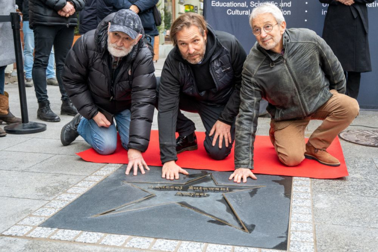 Łódź, 24.11.2021. Operator Andrzej Jaroszewicz (L), reżyser Xawery Żuławski (C) i aktor Mateusz Żuławski (P) biorą udział w odsłonięciu gwiazdy reżysera i scenarzysty Andrzeja Żuławskiego, w Łódzkiej Alei Gwiazd na ul. Piotrkowskiej. Fot. PAP/G. Michałowski