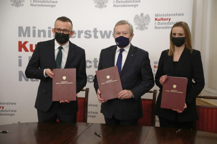Warszawa, 23.12.2021. Wicepremier, minister kultury i dziedzictwa narodowego Piotr Gliński (C), prezydent Zamościa Andrzej Wnuk (L) oraz skarbnik Zamościa Katarzyna Bucior (P) podczas uroczystości podpisania umowy o współprowadzeniu Orkiestry Symfonicznej im. Karola Namysłowskiego w Zamościu. Fot. PAP/W. Olkuśnik