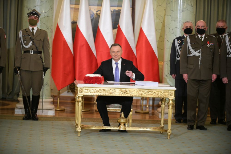 Prezydent RP Andrzej Duda (C), Dowódca Generalny Rodzajów Sił Zbrojnych gen. Jarosław Mika (2P) oraz Inspektor Sił Powietrznych RP gen. Jacek Pszczoła (3P) podczas uroczystości podpisania ustawy o obronie ojczyzny. Fot. PAP/M. Obara