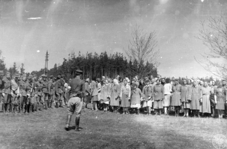 Żołnierze Brygady Świętokrzyskiej NSZ (po lewej) i grupa uwolnionych więźniarek (po prawej) z wyzwolonego obozu w Holýšovie. 05.05.1945. Fot. AIPN 
