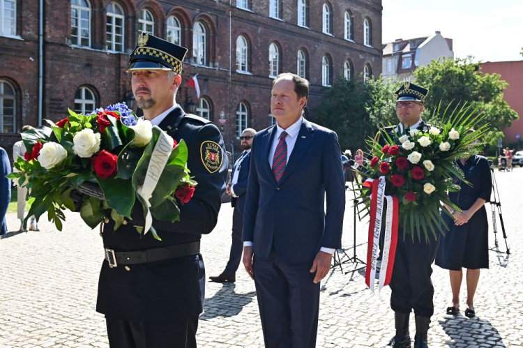  Gdańsk, 09.08.2022. Ambasador USA w Polsce Mark Brzezinski (C) podczas uroczystości złożenia kwiatów przy pomniku Obrońców Poczty Polskiej w Gdańsku. Fot. PAP/M. Gadomski 