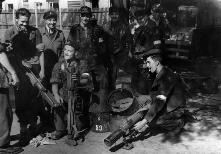 Powstańcy z Batalionu "Czata 49" wyciągający z zasobników lotniczych granatniki PIAT. Źródło: Wikimedia Commons