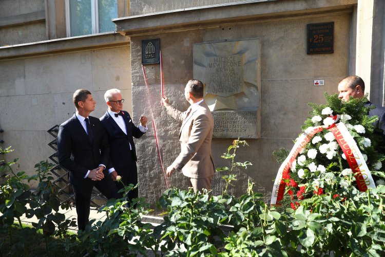 Prezes Instytutu Pamięci Narodowej Karol Nawrocki (3L), wiceminister edukacji i nauki Dariusz Piontkowski (L) oraz dyrektor generalny w MEiN Sławomir Adamiec (2L) podczas uroczystości odsłonięcia tablicy "Pomnik Historii" na gmachu MEiN oraz złożenia kwiatów pod tablicą upamiętniającą ofiary katowni przy ul. Szucha w Warszawie. Fot. PAP/R. Guz