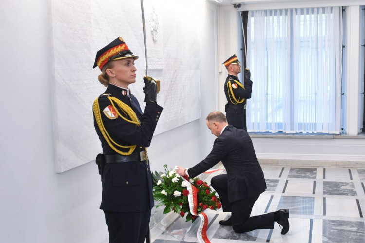 Warszawa, 28.11.2022. Prezydent Andrzej Duda (C) złożył kwiaty przed tablicą upamiętniającą senatorów II Rzeczypospolitej pomordowanych, poległych, zaginionych, zmarłych w latach II wojny światowej i powojennym okresie represji. Fot. PAP/R. Pietruszka 