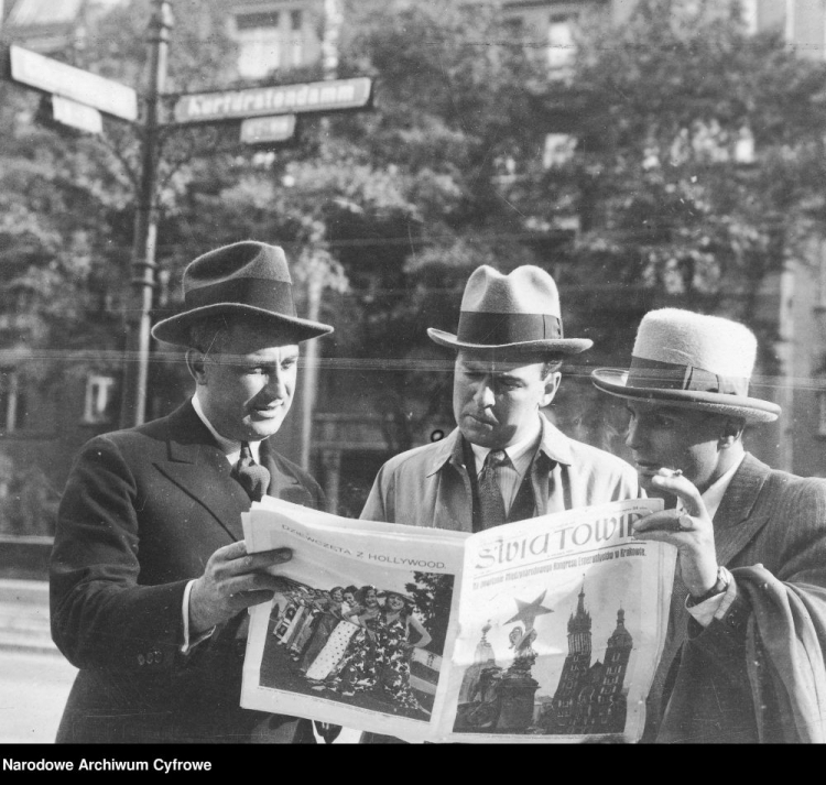 Reżyser filmowy Józef Lejtes, publicysta i teatrolog Michał Orlicz i operator filmowy Weyman przeglądają na ulicy tygodnik "Swiatowid". 1931 r. Fot. NAC