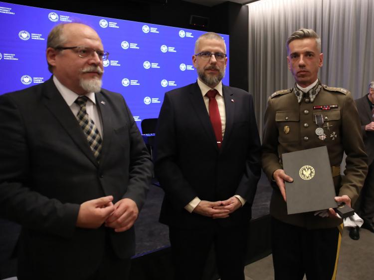 Warszawa, 11.10.2023. Dyrektor Biura Upamiętniania Walk i Męczeństwa IPN Adam Siwek (L) oraz zastępca dyrektora Oddziału IPN w Warszawie Zbigniew Siedlewski (C) wręczają medal Reipublicae Memoriae Meritum dowódcy Szwadronu Honorowego 3. Pułku Szwoleżerów Mazowieckich rotm. kaw. och. Piotrowi Szakaczowi (3L) w Centrum Edukacyjnym Przystanek Historia im. Janusza Kurtyki w Warszawie. Fot. PAP/A. Zawada