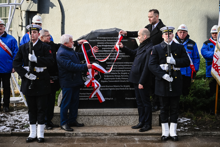 Prezes Instytut Pamięci Narodowej dr Karol Nawrocki (4P), przewodniczący Zarządu Regionu Gdańskiego NSZZ „Solidarność” Krzysztof Dośla (4L), uczestnik strajku sierpniowego w Stoczni i członek NSZZ „Solidarność” Krzysztof Żmuda (5L) oraz wiceprezes Zarządu Remontowa Shipbuilding Bartłomiej Pomierski (5P) podczas uroczystości odsłonięcia tablicy upamiętnieniającej Kasę Wzajemnej Pomocy, poprzedniczkę Bractwa Oblatów św. Brygidy. Fot. PAP/M. Gadomski