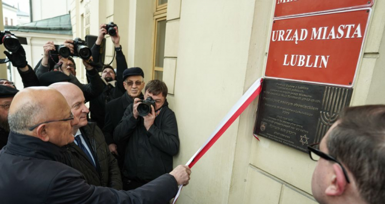 Lublin, 13.02.2024. Prezydent Lublina Krzysztof Żuk (L) i marszałek województwa lubelskiego Jarosław Stawiarski (2L) przed ratuszem w Lublinie, na odsłonięciu Tablicy Pamięci Żydów z Lublina, Ofiar niemieckiej zbrodniczej akcji „Reinhardt”. Fot. PAP/K. Zienkiewicz