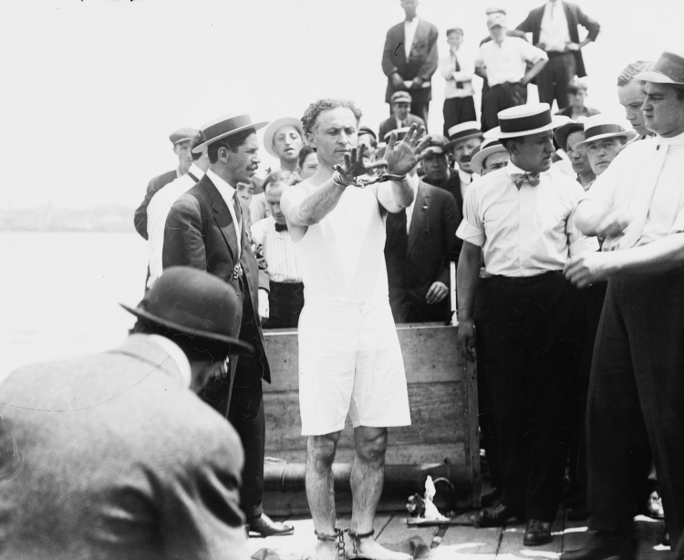 Houdini przygotowuje się do swojego popisowego numeru, zdjęcie wykonane ok. 1912 roku. / Źródło: en.wikipedia.org