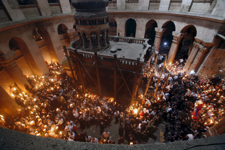 Wierni trzymają zapalone świece w Bazylice Grobu Pańskiego w Jerozolimie, podczas ceremonii tzw. Cudu Świętego Ognia w prawosławną Wielką Sobotę. Fot. PAP/EPA/N. Shohat