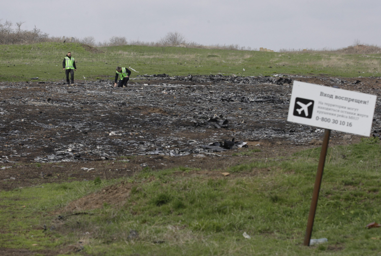 Śledczy przeczesują miejsce katastrofy pasażerskiego odrzutowca MH17 malezyjskich linii lotniczych obok tabliczki z napisem „Zakaz wstępu!” PAP/EPA/Alexander Ermochenko