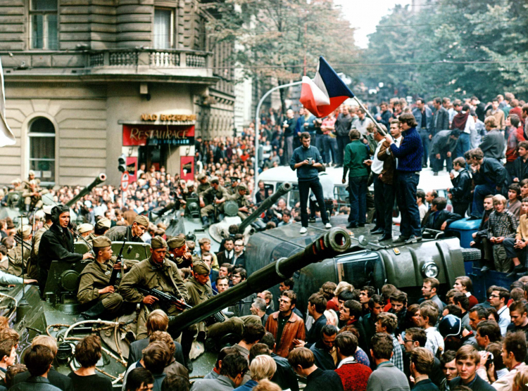 Młodzi mieszkańcy Pragi stoją na przewróconej ciężarówce, gdy inni otoczyli sowieckie czołgi 21 sierpnia 1968 r. w centrum miasta. Fot. PAP/CTK/L. Hajsky