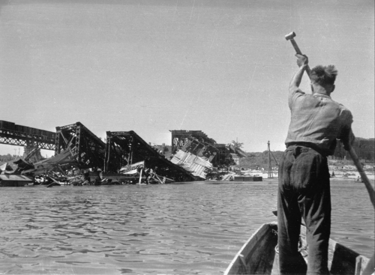 Zwalone przęsła mostu kolejowego pod Cytadelą. Za nim widoczny zbudowany prowizoryczny drewniany most kolejowy. Warszawa, 1945 r. Fot. PAP/CAF