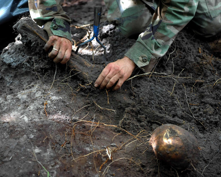 Archeolog wydobywa ze zbiorowej mogiły ludzkie kości znalezione na tzw. trupim polu w rejonie wsi Ostrówki na Ukrainie podczas ekshumacji w 2011 r. Pogrzebano tam szczątki około 300 Polaków, którzy w 1943 roku zginęli z rąk UPA. Fot. PAP/D. Delmanowicz