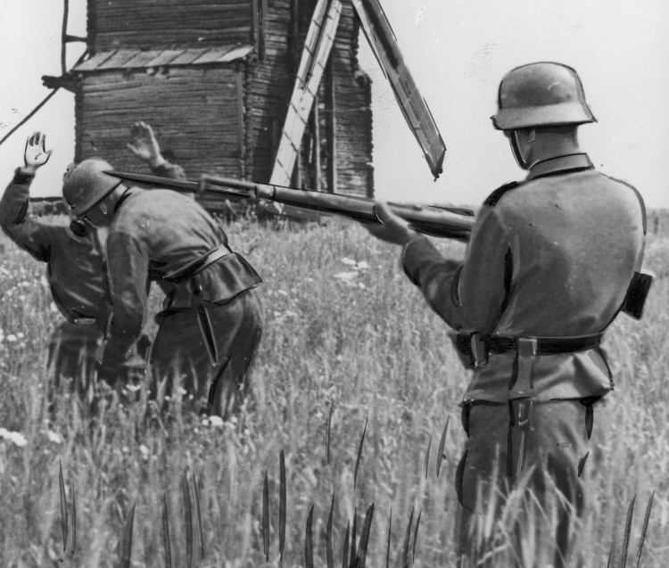 Niemieccy żołnierze rewidują cywila w poszukiwaniu broni, 1942 r. /Źródło: NAC