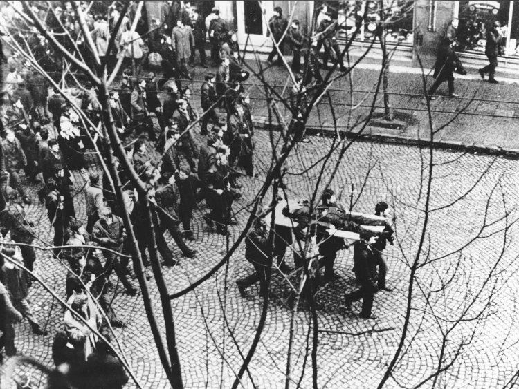 Ulicą Świętojańską w kierunku centrum przechodzi pochód, demonstranci niosą na drzwiach zwłoki Zbigniewa Godlewskiego. Zbigniew Godlewski zginął w okolicy przystanku Szybkiej Kolei Miejskiej Gdynia Stocznia, przeszyty serią z karabinu maszynowego. Gdynia 17.12.1970. PAP/Edmund Pepliński