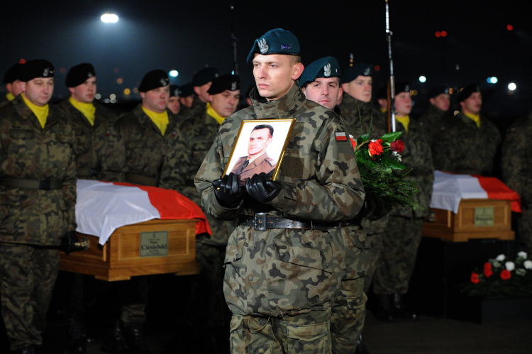 Samolot C-130 Hercules z ciałami pięciu polskich żołnierzy, którzy zginęli w Afganistanie wylądował na wojskowym lotnisku na Okęciu. W ceremonii uroczystego powitania poległych wzięła udział rodzina żołnierzy, przedstawiciele władz wojskowych i państwowych. W Afganistanie zginęli: mł. chor. Piotr Ciesielski, sierż. Łukasz Krawiec, sierż. Marcin Szczurowski, sierż. Marek Tomala i sierż. Krystian Banach. Warszawa, 23 grudnia 2011 r. PAP/Grzegorz Jakubowski
