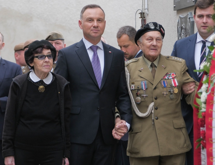 Prezydent RP Andrzej Duda (C), z córką rotmistrza Witolda Pileckiego Zofią Pilecką-Optułowicz (C-L) i weteranem Januszem Walędzikiem (C-P) podczas uroczystości złożenia wieńca przy Ścianie Śmierci na terenie Muzeum Żołnierzy Wyklętych i Więźniów Politycznych PRL w 2023 r. (sko) PAP/Mateusz Marek