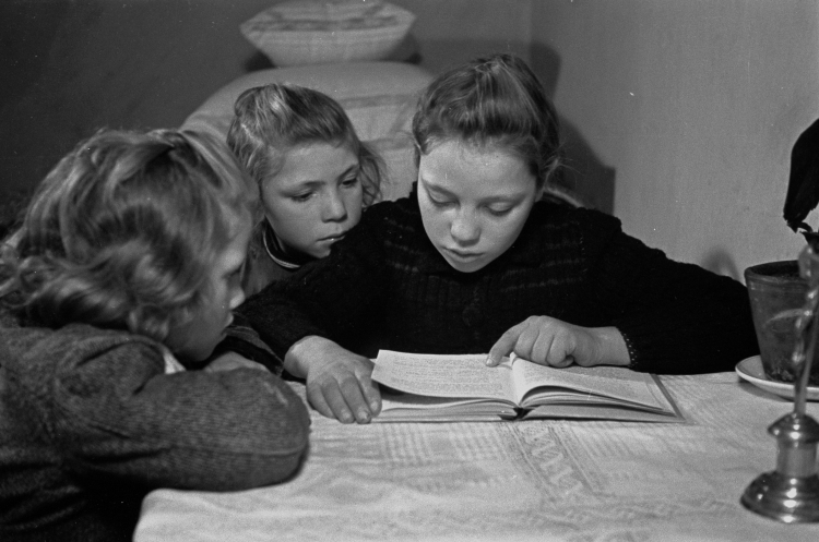 Konopki, 1949-01-16. Czytelnictwo na wsi. Nz. 12-letnia Teresa Jankowska czyta z siostrami książkę, wypożyczoną z nowo otwartej gminnej biblioteki w Pustelniku k. Mińska Mazowieckiego. PAP