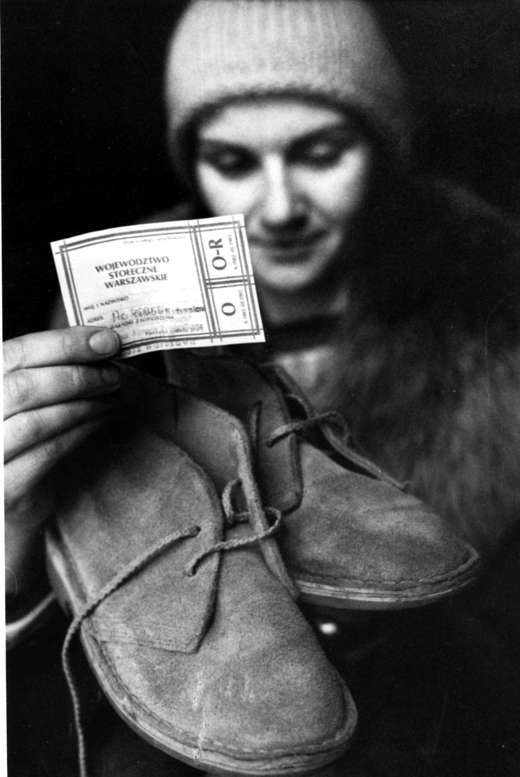 Kobieta prezentuje kartki na obuwie. Zdjęcie z lutego 1983 r. Fot. PAP/CAF/Marek Broniarek