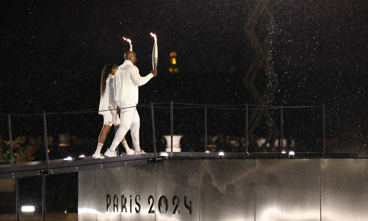 Marie-Jose Perec (po lewej) i Teddy Riner (po prawej) z pochodniami podczas ceremonii otwarcia Igrzysk Olimpijskich Paryż 2024. PAP/EPA/Jan Woitas