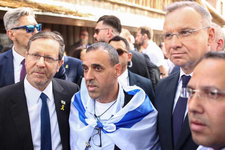 Prezydent RP Andrzej Duda (P) i prezydent Izraela Isaac Herzog (L) podczas przywitania z Ocalałymi z Holokaustu przed Bramą „Arbeit macht frei” w Państwowym Muzeum Auschwitz Birkenau. PAP/Jarek Praszkiewicz