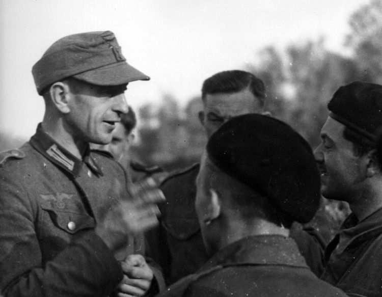 Przymusowo wcielony do Wehrmachtu Polak rozmawia z żołnierzami 1 Dywizji Pancernej gen. Stanisława Maczka. Normandia, 1944 r. Fot. Evan McGilvray, Public domain, via Wikimedia Commons
