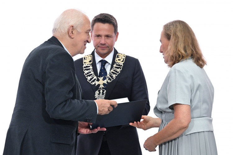 Prezydent Warszawy Rafał Trzaskowski (C), przewodnicząca Rady m.st. Warszawy Ewa Malinowska-Grupińska (P) i prof. Andrzej Friszke (L), któremu wręczono tytuł Honorowego Obywatela m.st. Warszawy na uroczystej Sesji Rady m.st. Warszawy w Dużej Auli Politechniki Warszawskiej. Fot. PAP/Radek Pietruszka