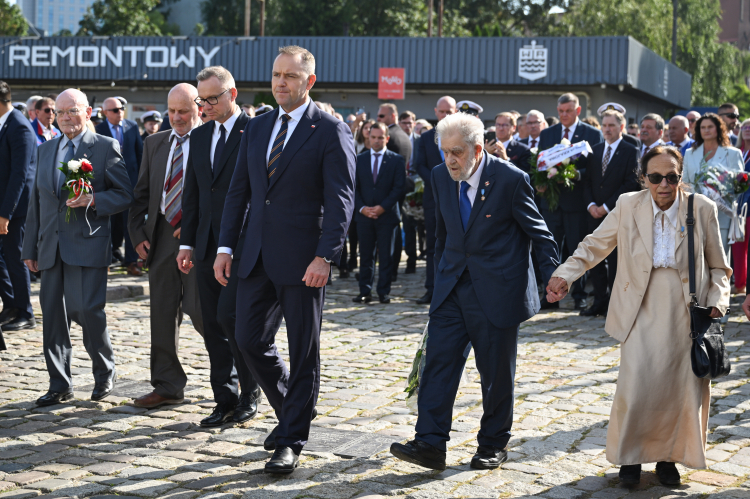 Uroczystości w Stoczni Gdańskiej: pierwszy od lewej sygnatariusz Porozumień Sierpniowych w delegacji rządowej Tadeusz Fiszbach, trzeci od lewej b. prezydent Andrzej Duda, w środku prezydent Karol Nawrocki, pierwsza od prawej opozycjonistka Joanna Duda-Gwiazda, drugi od prawej współtwórca Wolnych Związków Zawodowych Wybrzeża i NSZZ Solidarność Andrzej Gwiazda. Fot. PAP/Adam Warżawa