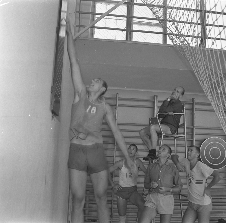 Gdańsk, 14.08.1964. Przygotowania polskiej reprezentacji w piłce koszykowej do Letnich Igrzysk Olimpijskich w Tokio. Trener Witold Zagórski po powrocie z USA, gdzie przebywał w celach szkoleniowych, prowadzi zgrupowanie polskiej kadry. Na zdjęciu zawodnik Bohdan Likszo (L) podczas wykonywania testów skoczności, obok trener Zagórski (stoi 2P). Z prawej zawodnik Krzysztof Sitkowski, z lewej z nr. 12 Zbigniew Dregier, na stołku sędziowskim asystent trenera Jan Mikułowski. Fot. PAP/Janusz Uklejewski